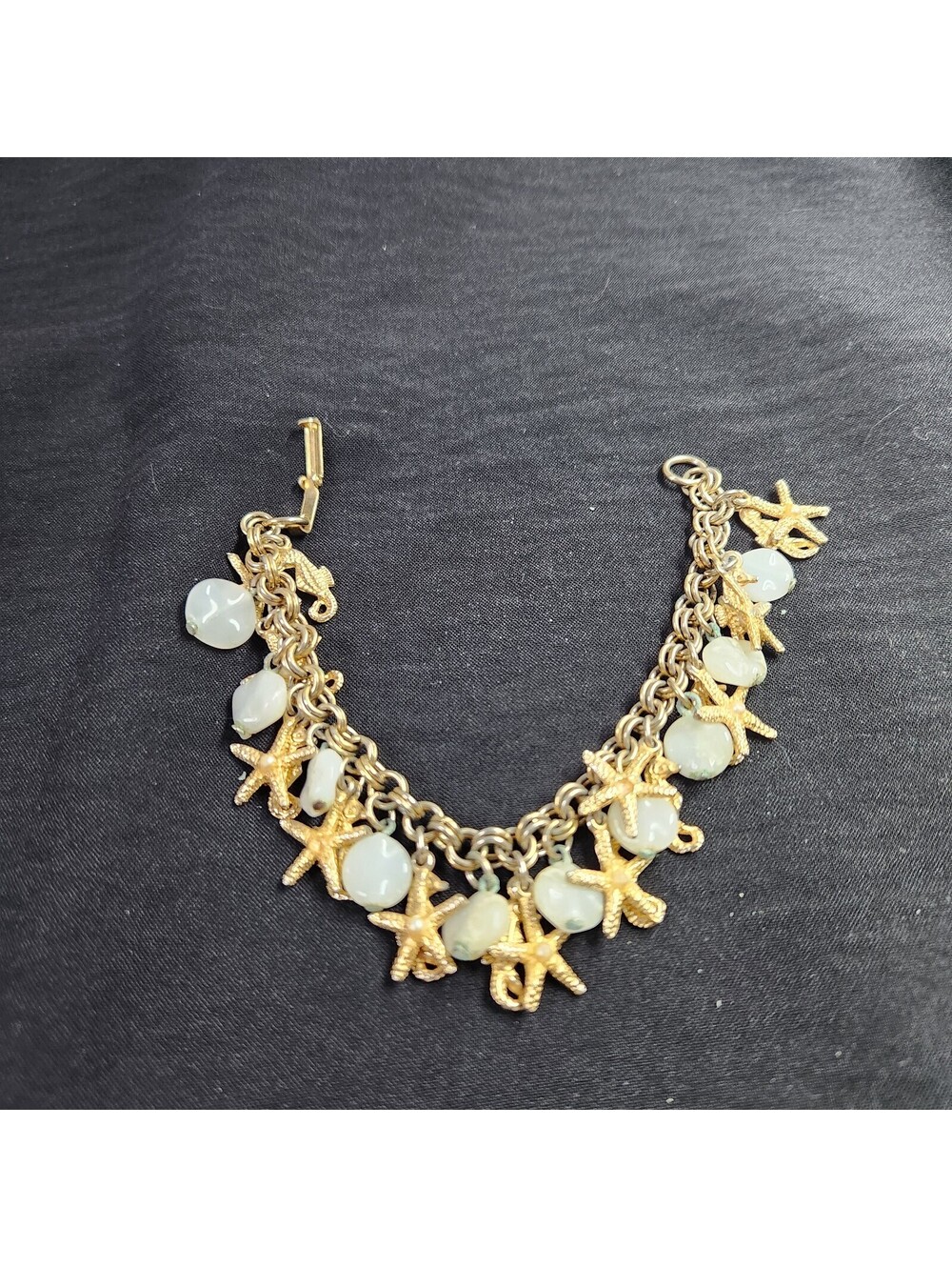 Gold tone seashell and starfish charm bracelet